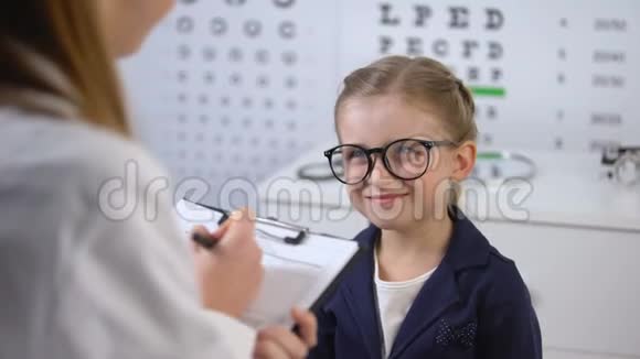 可爱的微笑女孩等待眼镜医生处方治疗技巧视频的预览图