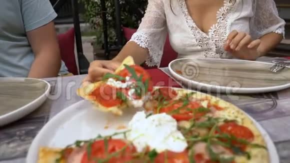 在咖啡馆里吃披萨的年轻女人视频的预览图