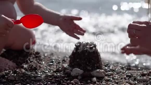一个小孩子慢慢地在海滩上挖地筑城堡视频的预览图