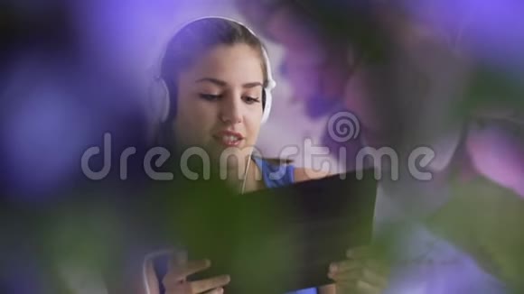 微笑的女人在耳机里欣赏音乐的肖像耳机时尚模特视频的预览图