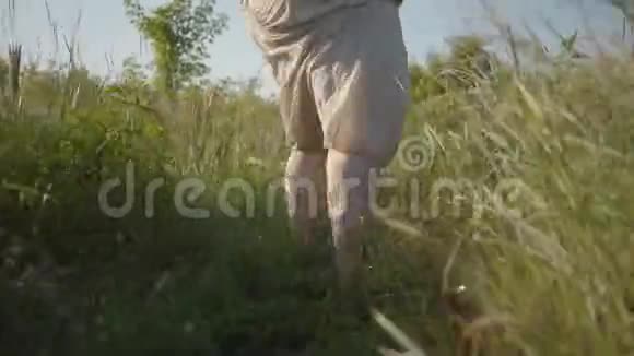 背部观看超重妇女穿着夏季亚麻衣服跑在田野转身和看镜头连接视频的预览图