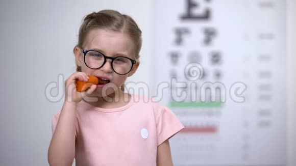 快乐可爱的眼镜女孩吃胡萝卜维生素A的视力好健康视频的预览图