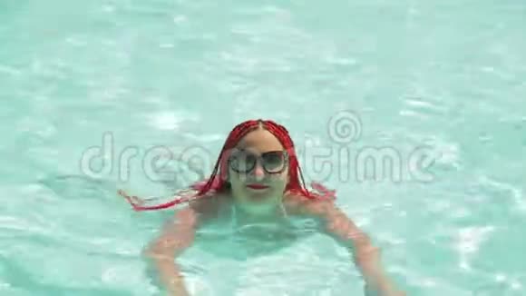 一个穿白色泳衣的年轻女子在游泳池里游泳视频的预览图