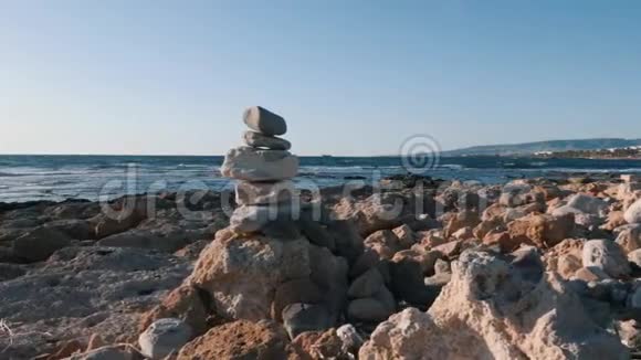 排列在海滩上的石头金字塔海边的石塔在海滩上合上一叠平衡的鹅卵石平衡的石头视频的预览图