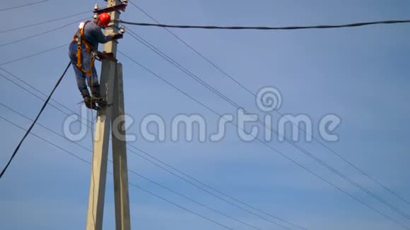 一名电工在新安装的电线杆上工作连接一条新的电力线视频的预览图