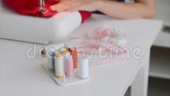 裁缝女士正在制作新衣服并在餐桌上的缝纫机上缝纫视频的预览图