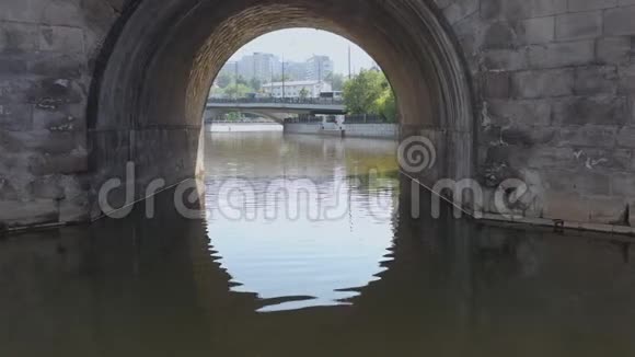 沿着城市的河流在古老的石桥下视频的预览图