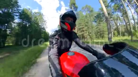 一个人骑着摩托车沿着树木的侧面景色视频的预览图