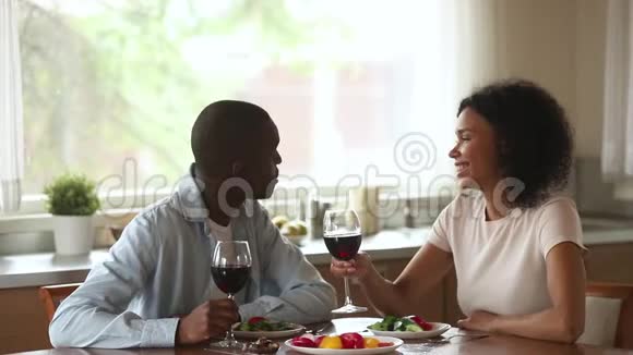 快乐的非洲夫妇喜欢聊天喝酒坐在桌子上视频的预览图