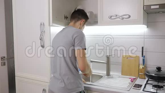 男人在家里厨房里洗盘子视频的预览图