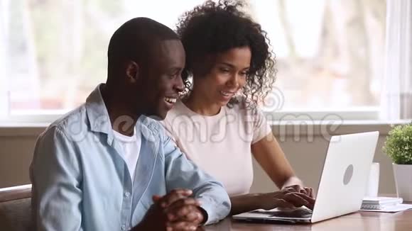 兴奋不已的非洲情侣看着笔记本电脑被网上赢了视频的预览图