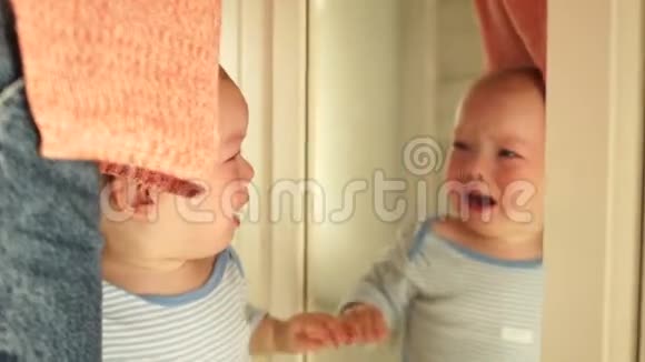 孩子哭着同时看着镜子里的自己婴儿正在哭泣站在母亲面前视频的预览图