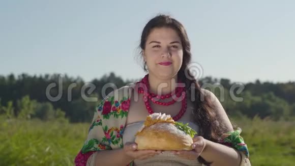 可爱丰满的女人在白面包上提出猪油的肖像微笑着看着相机招待费视频的预览图