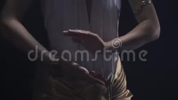 穿着白色裙子的克利奥帕特拉在一个黑暗的房间里靠近视频的预览图