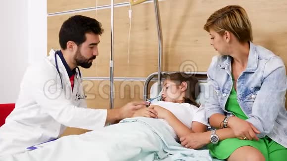 生病的女孩躺在病床上医生检查她的体温视频的预览图