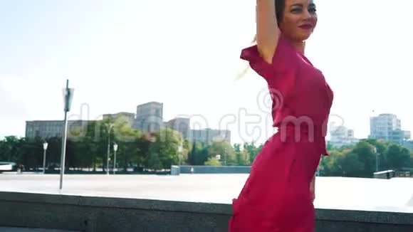 穿着红色裙子的金发女人在外面慢动作的感觉中跳舞视频的预览图