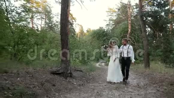 恋爱中的情侣沿着森林路散步视频的预览图