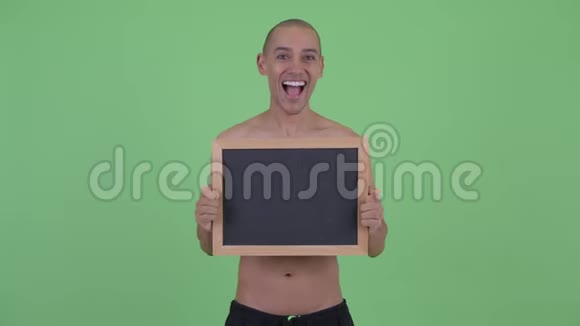 快乐的秃头多民族赤膊男子拿着黑板看上去很惊讶视频的预览图