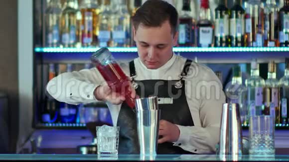 酒保在酒吧做鸡尾酒从摇床倒到杯子里视频的预览图
