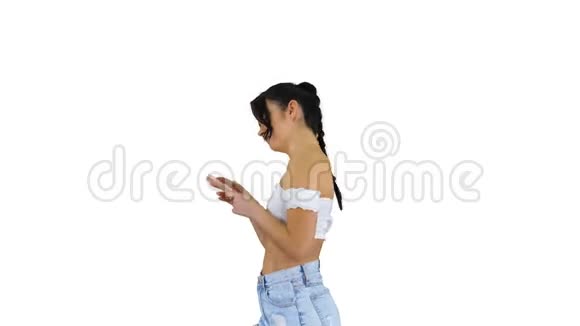 可爱的女孩检查她的手机和跳舞的白色背景视频的预览图