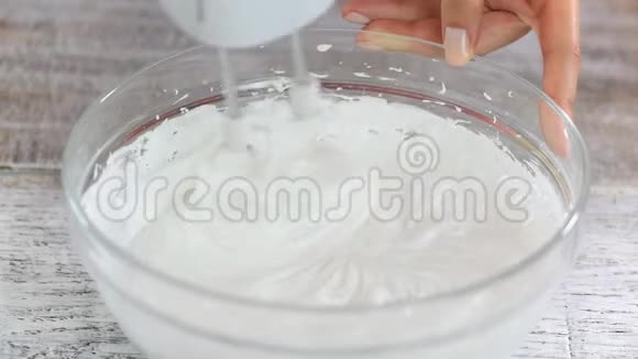 制作月桂的阶段用糖打蛋清直到达到光滑和僵硬的峰值视频的预览图