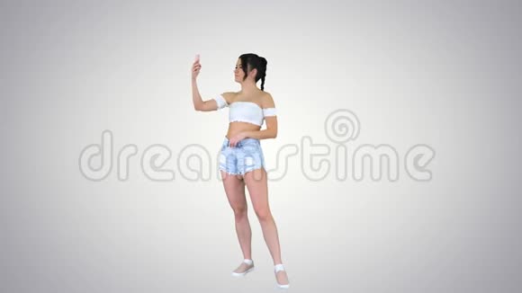 可爱的黑发女孩自拍和跳舞的梯度背景视频的预览图