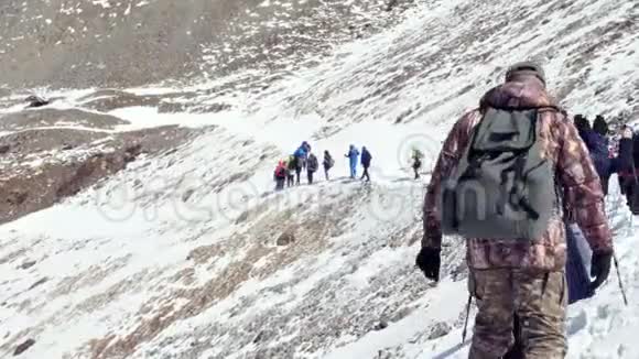 团队合作游客在冬天下雪登山山顶岩石峰团队视频的预览图