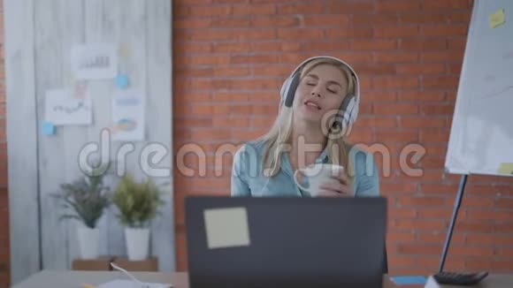 开朗的女孩在办公室听音乐第一次午休4k视频的预览图
