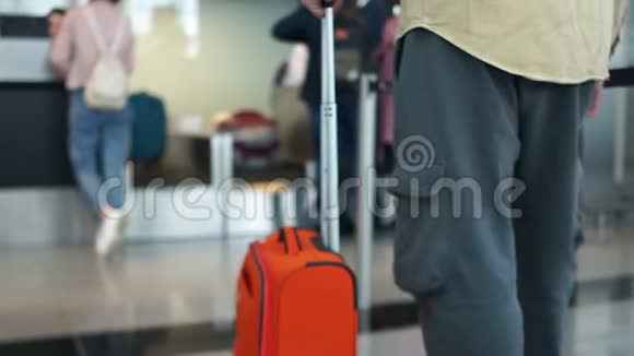 带着橙色手提箱的人在飞机起飞前排队办理登机手续航空旅行概念视频的预览图