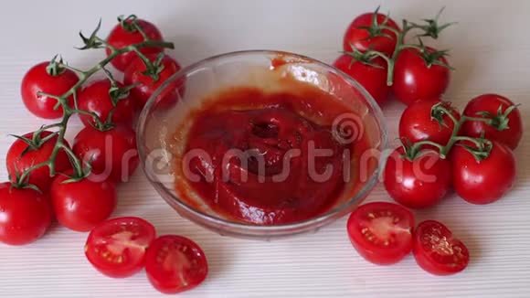 女人放进一小碗番茄酱躺在新鲜西红柿旁边视频的预览图