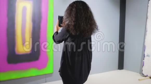 美术馆女嘉宾正在用智能手机拍照视频的预览图