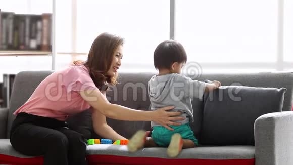 亚洲男孩在沙发上玩和他的母亲玩砖头视频的预览图