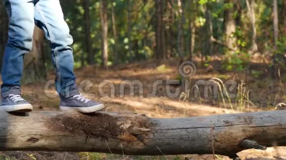 一个快乐的小孩子走在森林里的一根木头上克服障碍培养勇气和敏捷性未来和未来视频的预览图