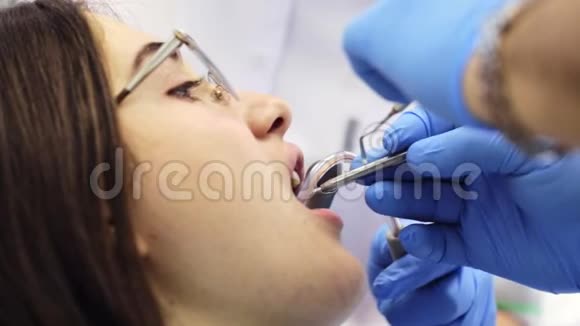 口腔医生正在用牙镜检查女性牙齿视频的预览图