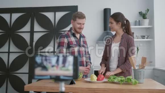 在线烹饪课程快乐的博客作者男人和女孩教订户烹饪有用的食物从蔬菜重量视频的预览图