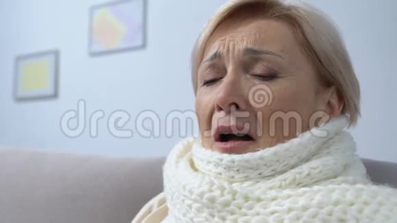 戴围巾的老太太患了流感组织打喷嚏季节性流行健康视频的预览图