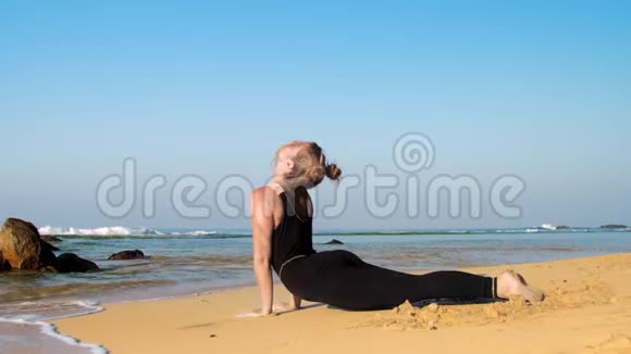 赤脚女孩在沙滩上做瑜伽运动后放松视频的预览图