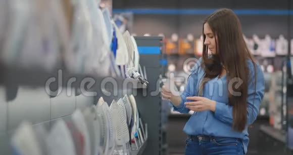 一个年轻漂亮的女人穿着一件衬衫拿着铁的特点研究价格选择买一件铁视频的预览图