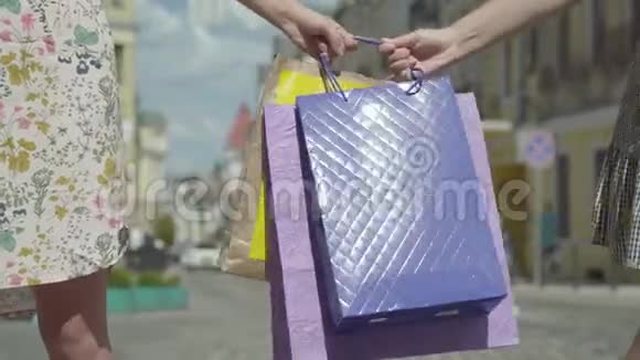 时尚女孩的特写双手拿着购物袋把她们拉到街边购物视频的预览图