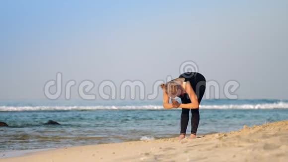 穿黑色运动服的金发女子练习呼吸瑜伽视频的预览图