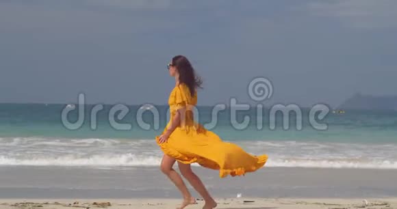 年轻漂亮的模特儿在海风中快乐地奔跑挥舞着她的连衣裙露出长腿视频的预览图