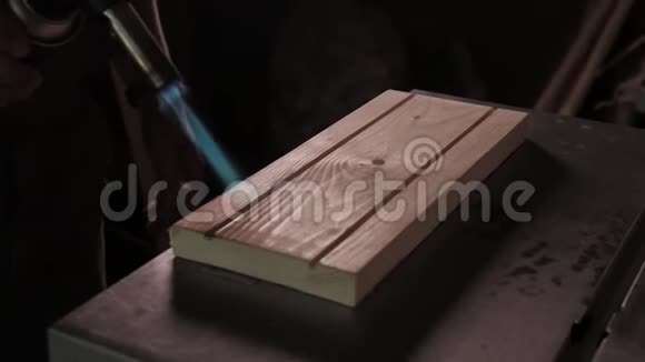 慢动作木匠用煤气燃烧器烧烤板用于发黑视频的预览图
