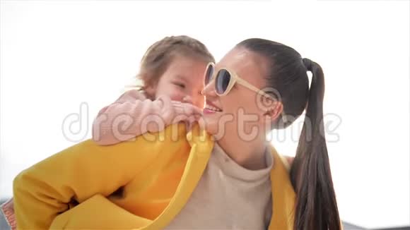 美丽而快乐的年轻母亲把猪背骑给她的女儿这个母亲节都很开心夏季城市视频的预览图