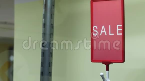 一个红色的销售标志上面的服装架一家小商店安排了一件打折的衣服视频的预览图