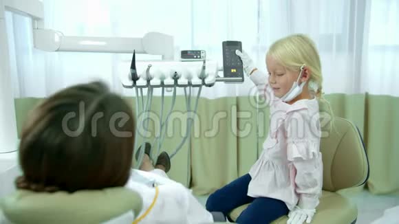 女孩控制着牙医坐着的椅子视频的预览图