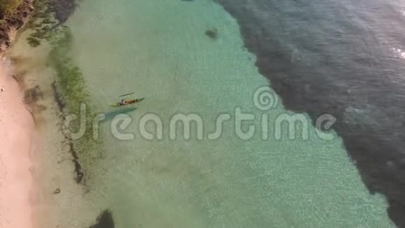 一个人的无人机镜头是在日出时沿着绿松石水从沙质海岸划艇电影院俯视图视频的预览图