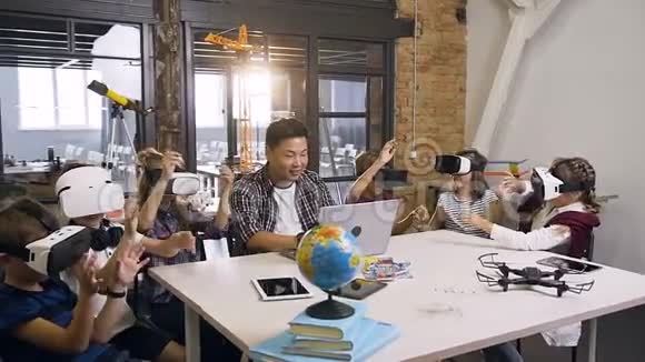 一位年轻的韩国教师在计算机科学中使用增强现实VR眼镜的六名高加索青年学生视频的预览图