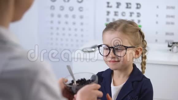 眼科医生把蓝莓送给可爱的小女孩用于眼睛的天然维生素视频的预览图