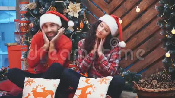 一对夫妇在圣诞树旁享受圣诞心情和乐趣的视频视频的预览图