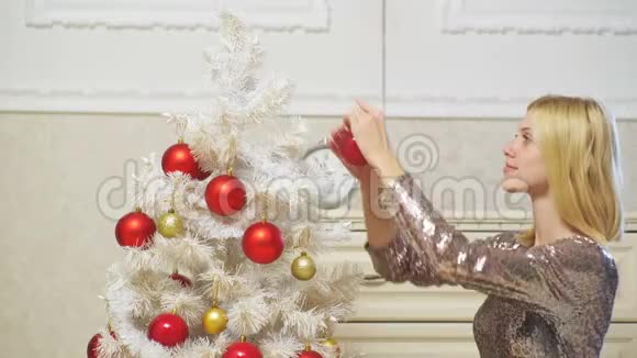 金发女孩装饰一棵白色的圣诞树红球孤立在白色上圣诞快乐新年快乐假期视频的预览图